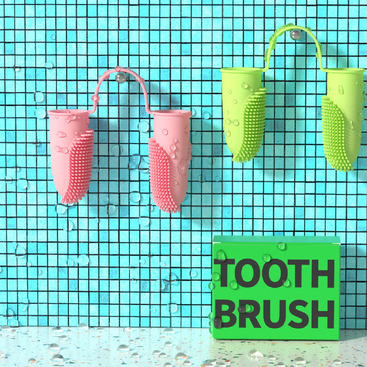 Pink and green silicone toothbrushes on a blue tiled background with a sign below them.
